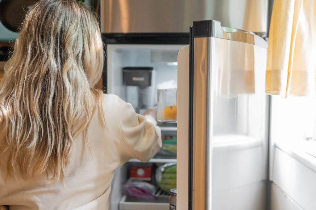Picture of a person looking inside a refrigerator