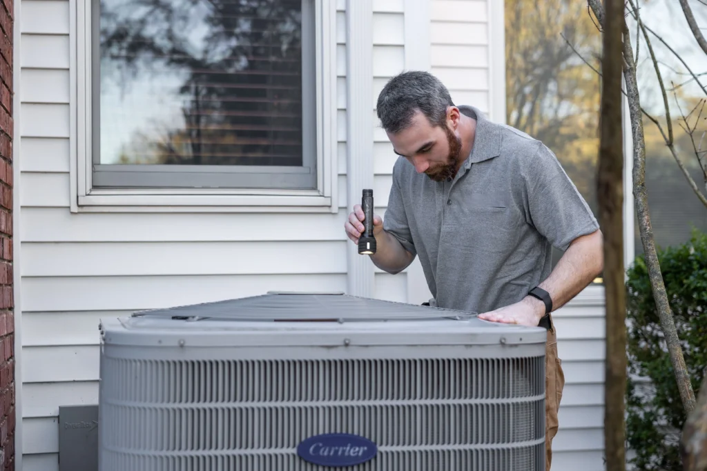 Picture of a technician inspecting an outdoor unit