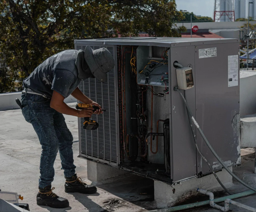 Picture of a technician repairing a commercial HVAC unit on a roof