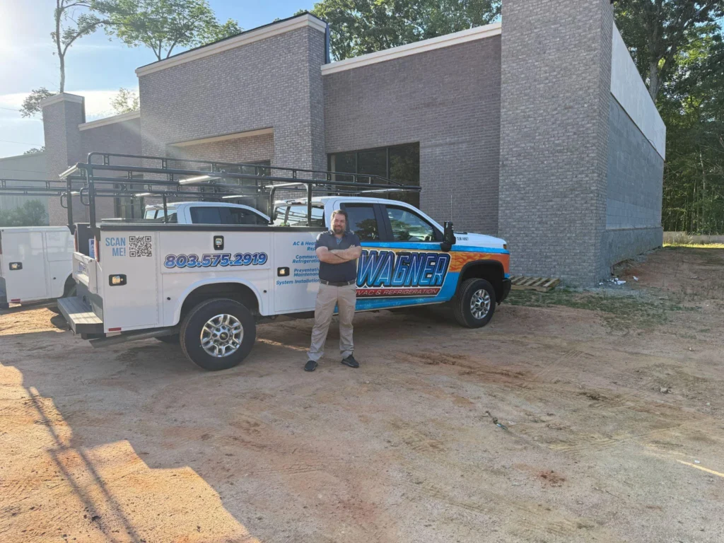 picture of a technician standing in front of wagner hvac work trucks