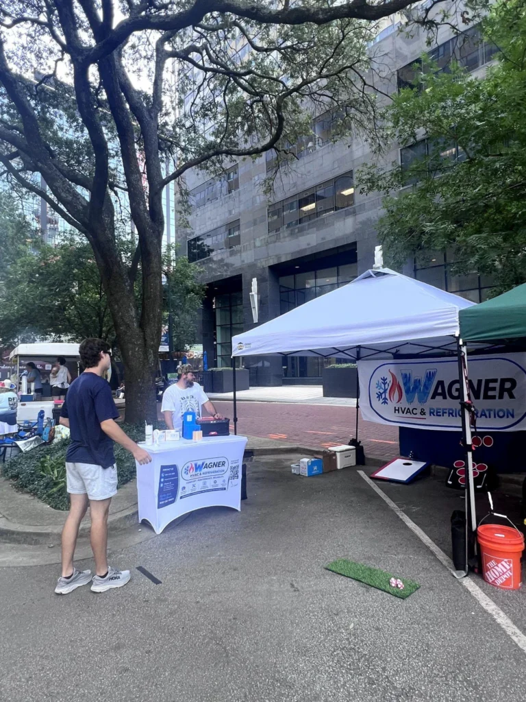 picture of a wagner hvac and refrigeration event tent with a cornhole game
