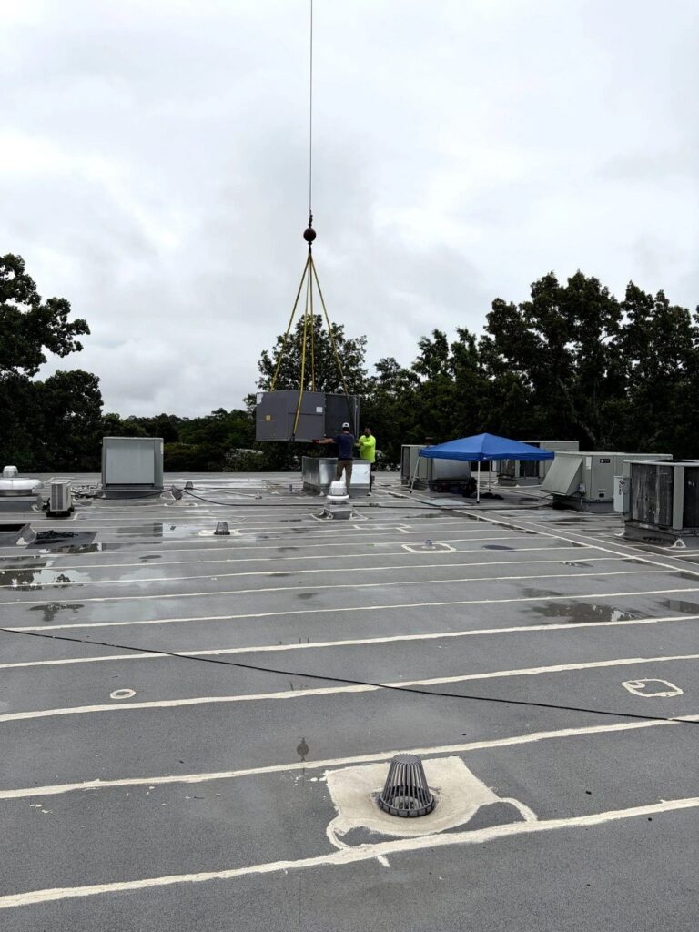 Picture of a crane lifting an HVAC unit onto a roof