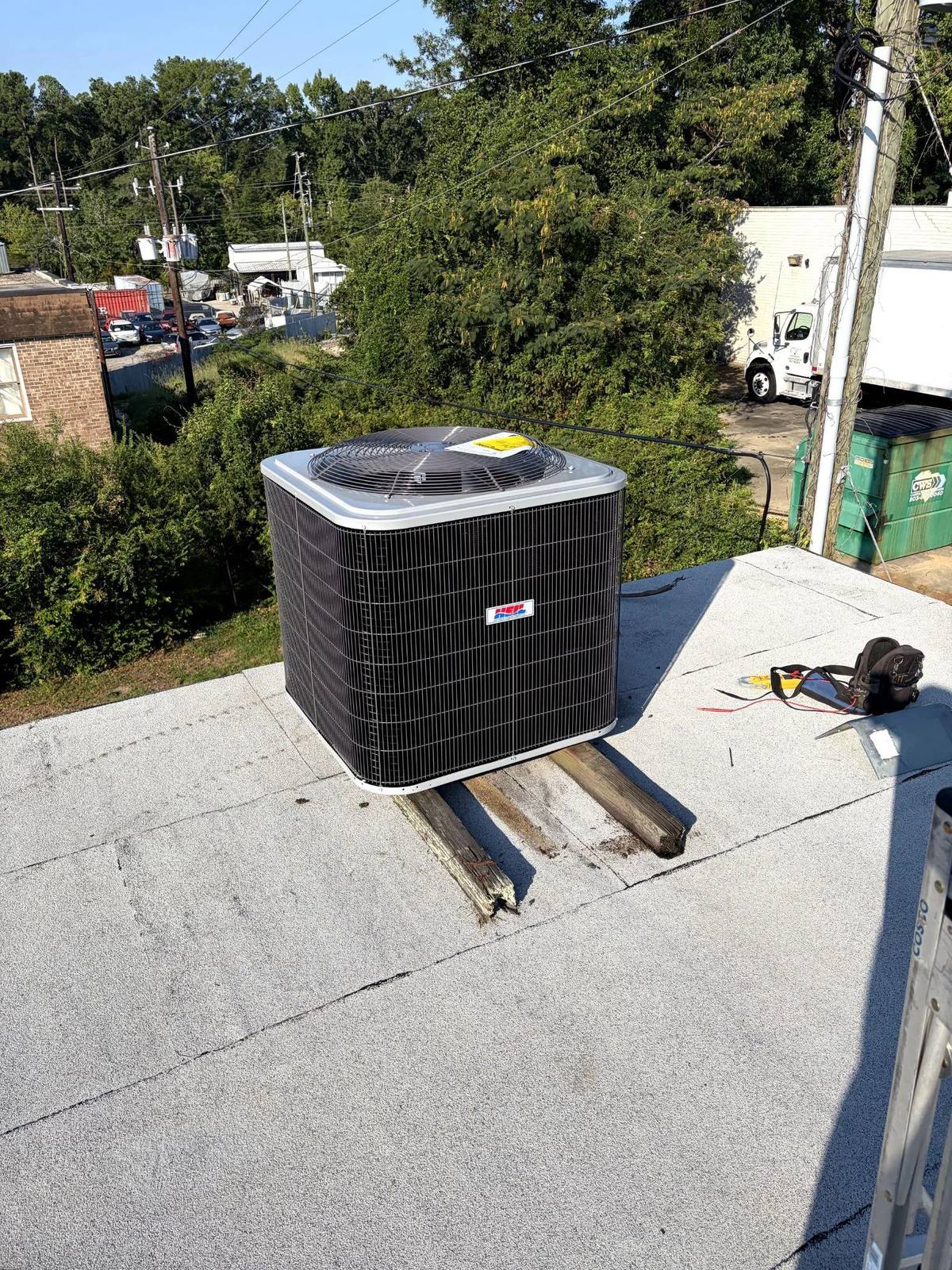 Picture of a rooftop HVAC unit installed on wooden supports