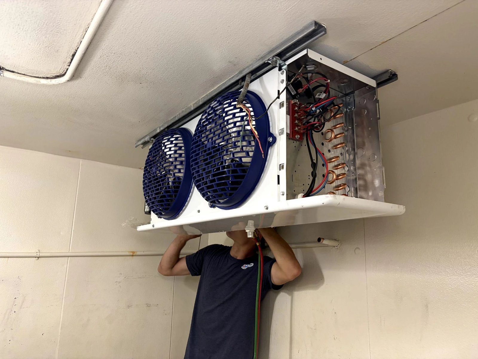 Picture of a technician installing an indoor refrigeration unit