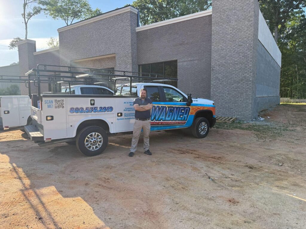 Picture of an HVAC technician standing next to a service truck